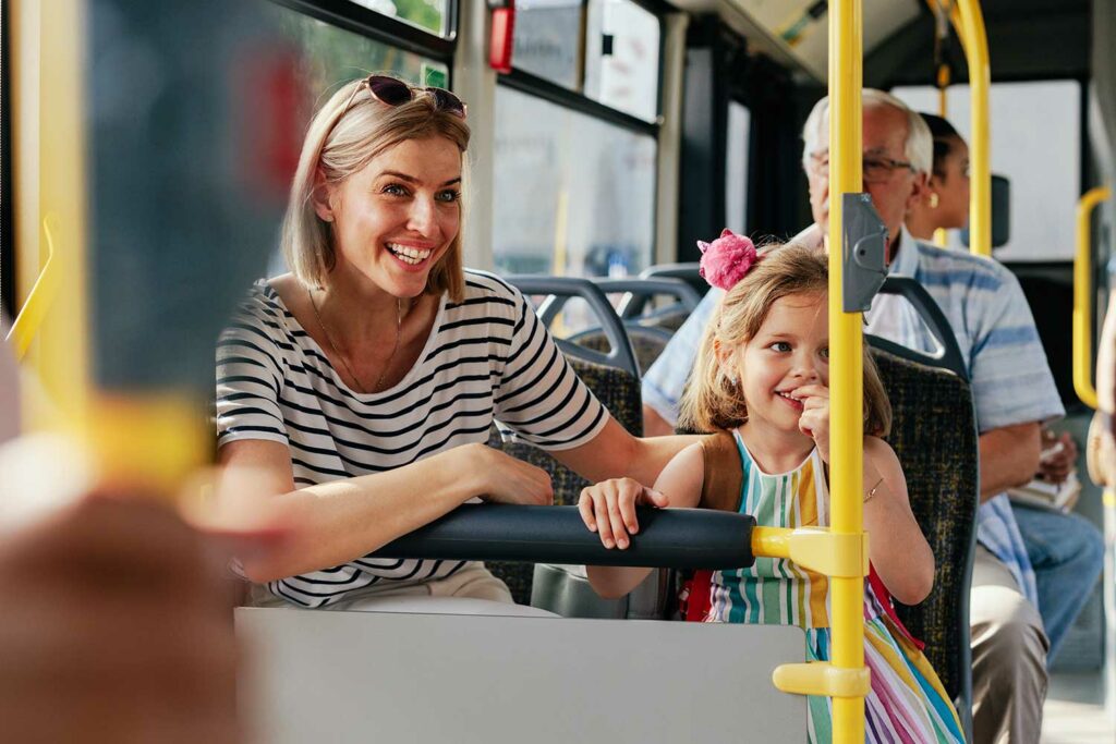 Mutter und Tochter mit weiteren Fahrgästen im Linienbus.